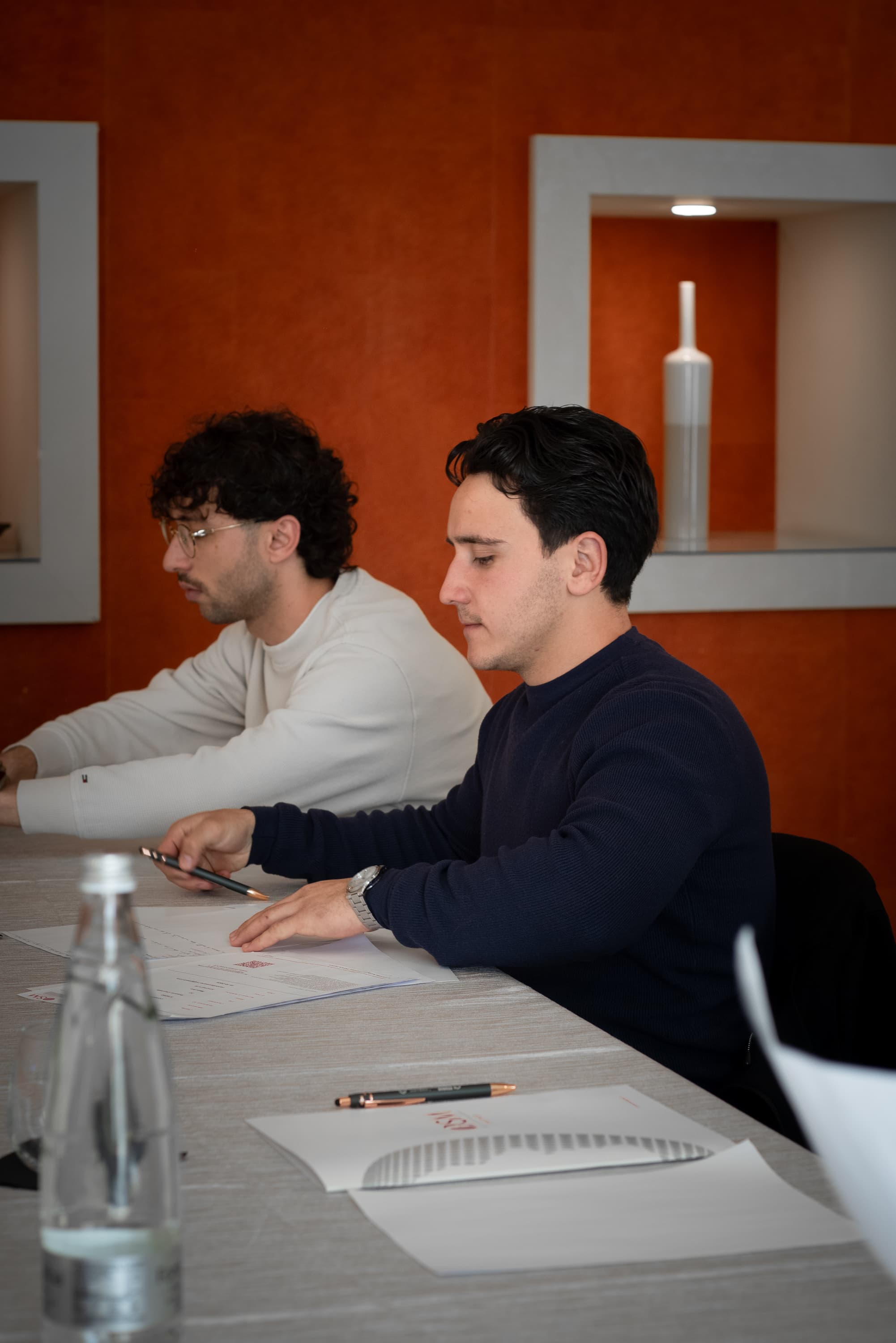 Due imprenditori lavorano a un esercizio al tavolo durante una giornata in aula